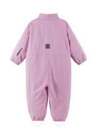 Combinaison imperméable rose avec poignets et pieds élastiques, dotée d'un patch logo et d'une texture lisse. Design classique pour les activités en plein air.