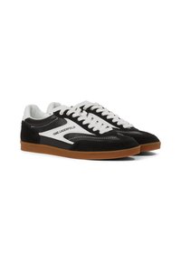 Baskets noir et blanc avec une tige en daim et cuir, dotées de lacets blancs, d'une semelle en caoutchouc gomme, et portant la marque "KARL LAGERFELD" sur le côté.
