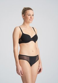 Zwarte lingerie set met een gladde, padded beha met mesh accenten en bijpassende bikini-cut slipjes met semi-doorzichtige panels.