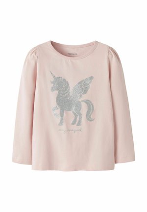 Chemise rose clair à manches longues avec un motif licorne pailletée argentée et des ailes, ainsi que les mots "stay magical" à l'avant.