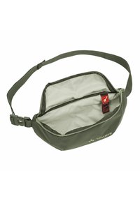 Sac de taille en tissu vert avec fermeture éclair, bandoulière réglable et deux compartiments, présentant une texture lisse et une étiquette intérieure rouge.