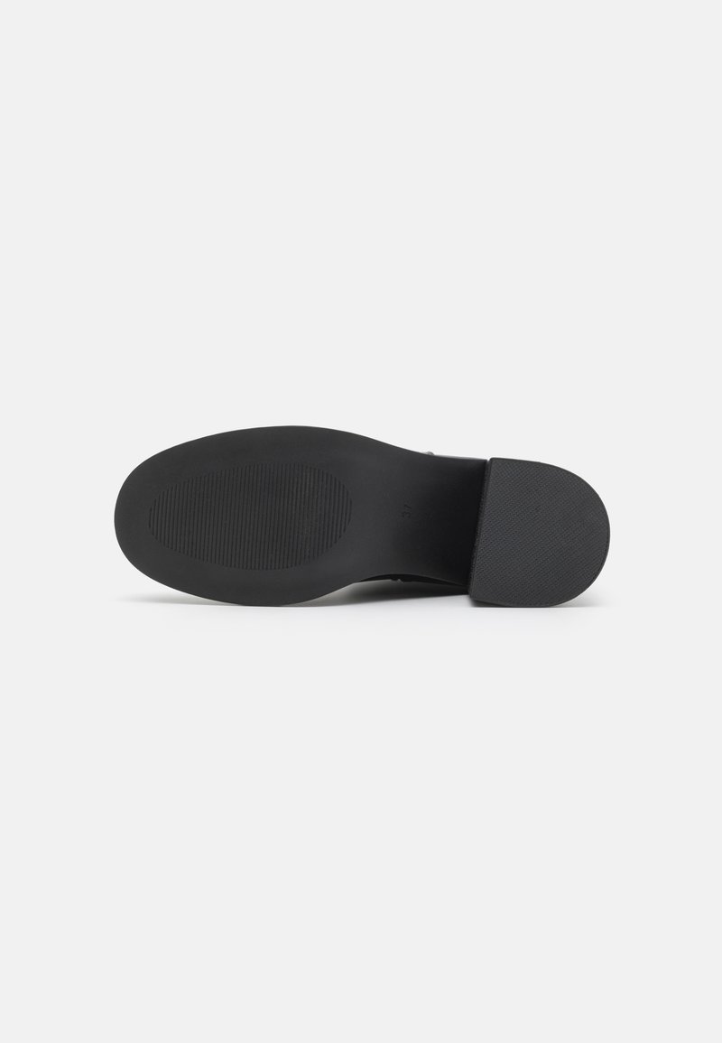 Sole di scarpa in gomma nera con grip testurizzato, forma arrotondata, tacco piatto e leggera curvatura per flessibilità. Nessun marchio visibile o motivi.