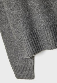 Grauer Strickpulloverstoff mit einem glatten Körper und geripptem Saum, der eine weiche Textur mit einem subtilen Glanz zeigt.