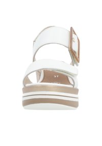Sandale blanche avec des larges brides, une accentuation par boucle et une semelle intérieure rembourrée. Présente une semelle superposée avec des rayures blanches et marron clair.