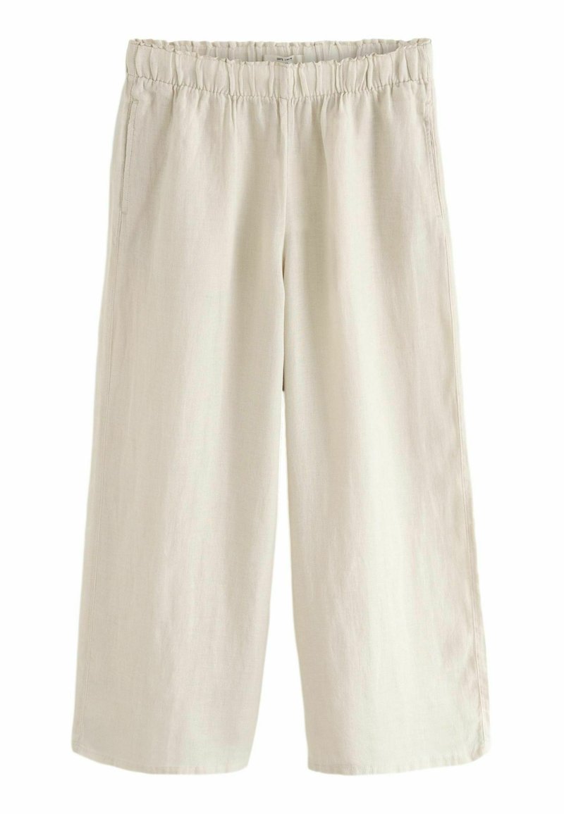 Pantaloni bej cu talie largă dintr-un material ușor; au un elastic la talie și buzunare laterale; textură netedă, pliuri căzute.