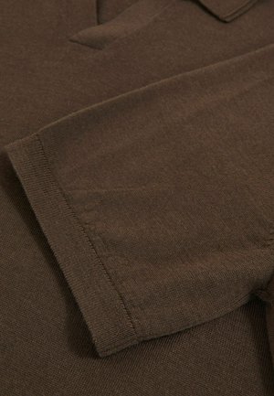 Brauner Strickstoff mit einer samtigen Textur, ausgestattet mit einem Kragen und kurzen Ärmeln. Das Design ist schlicht und kommt ohne Muster oder Verzierungen aus.