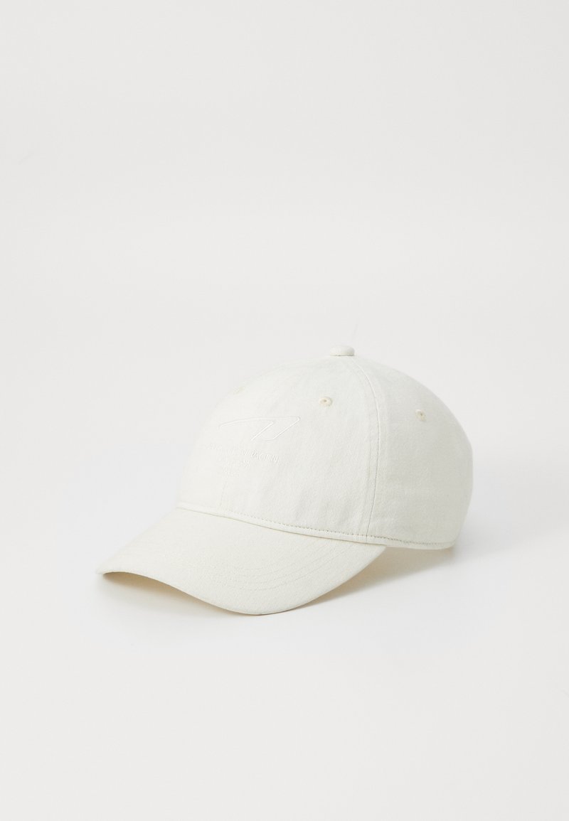 Casquette de baseball couleur crème en coton doux, avec une visière courbée et un logo en relief sur le devant.