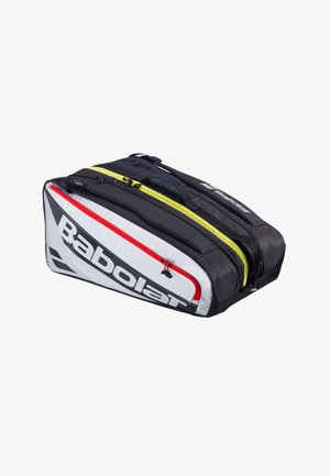 Borsa sportiva Babolat in bianco e nero con scomparti gialli e rossi, maniglie per il trasporto, progettata per attrezzatura da tennis.