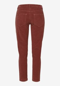 Pantalon en velours côtelé couleur rouille à coupe ajustée, avec deux poches arrière et des détails de couture subtils à la taille et aux poches.