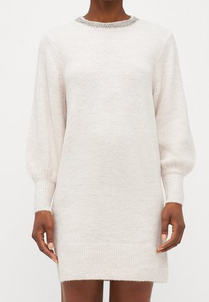 Gebreid sweaterjurk in lichtbeige met opgeblazen mouwen, geribbelde manchetten en zoom. Heeft een versierde halslijn voor extra detail.