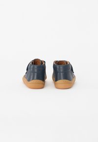Navy leather high-top shoes with a tan rubber sole, featuring a smooth texture and stitched detailing. Back view shows rounded heel design.