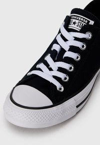 Must mustaga tennis jalan musta valge kummist varvasetipp ja tald. Omab valgeid paelu ja metallist silmi, logo on keeles ja külgede riba.