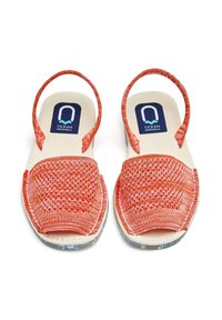 Sandalias tejidas naranjas con un empeine de patrón, correa de tobillo ajustable y plantilla acolchada. Suela transparente con un acabado texturizado.