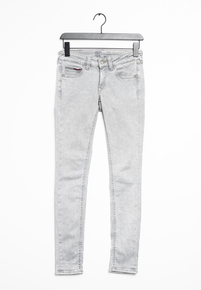 Jeans ajustados de color gris claro, confeccionados en denim, con una cintura baja, cinco bolsillos y una sutil textura desgastada. Disponibles en una percha.