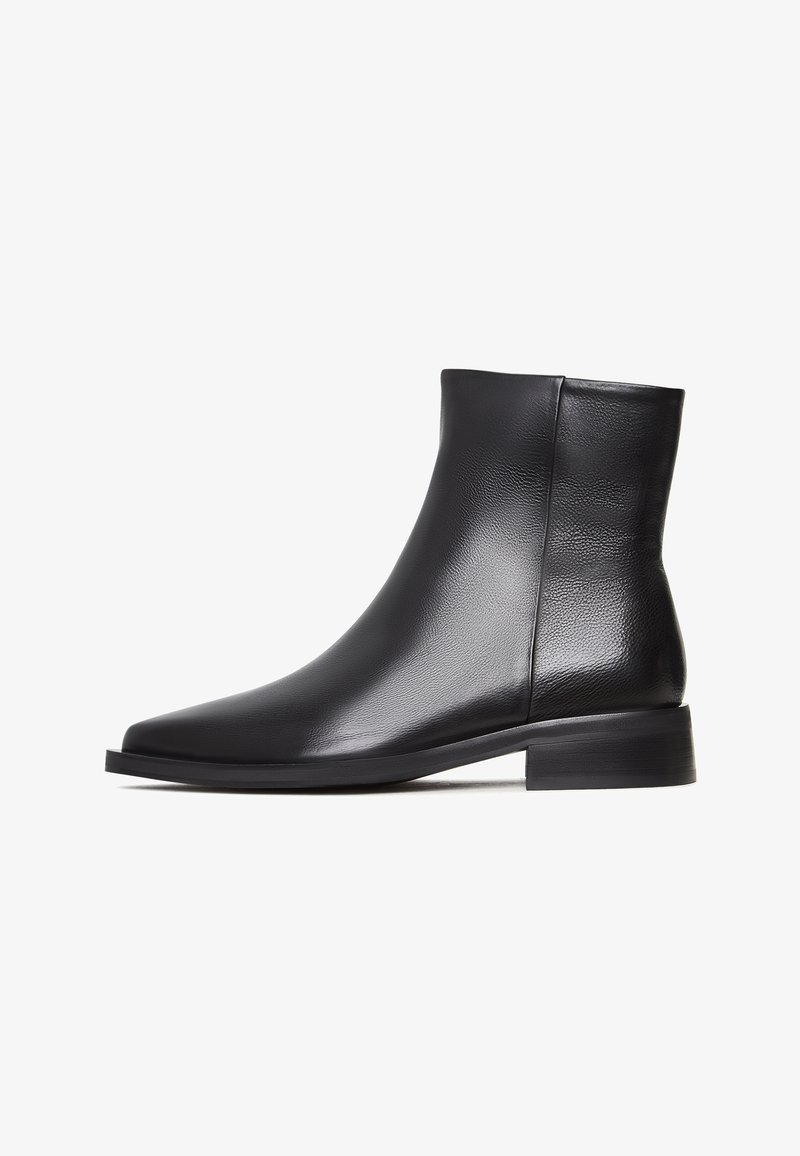 Bottine en cuir noir avec petit talon bloc, finition lisse et fermeture éclair latérale, vue de côté extérieur sur fond blanc.