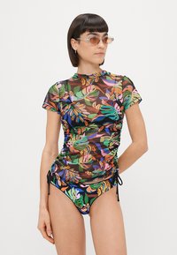Maiô floral multicolorido com um top transparente, laterais franzidas e design de gola alta. Tecido suave com silhueta ajustada e parte de baixo combinando.