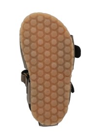 Tan rubberen zool met een hexagonaal patroon, met een bruine bovenkant en verstelbare banden. Ontworpen voor comfort en stabiliteit.