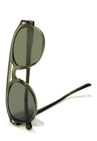 Vihreän vivahteen omaavat aurinkolasit, joissa on suuret ovaalinmuotoiset linssit ja paksu kehys. Silmälaseissa on siltaosassa leikattu muotoilu ja ohuet sankat.