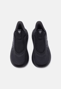 Ζευγάρι μαύρα αθλητικά παπούτσια slip-on με πλεκτό επάνω μέρος και διακριτικό λογότυπο της μάρκας στις πλευρές, εμφανιζόμενα από πάνω σε ένα απλό φόντο.