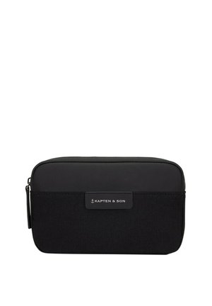 Czarna prostokątna saszetka Kapten & Son z zamkiem błyskawicznym, z sekcjami z materiału tkanego i gładkiego oraz naszywką z logo marki na przedniej części.