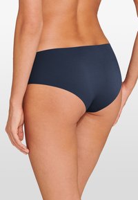 Navy blue bikini brief with a seamless design, made from a smooth material, featuring a mid-rise cut and full coverage at the back.