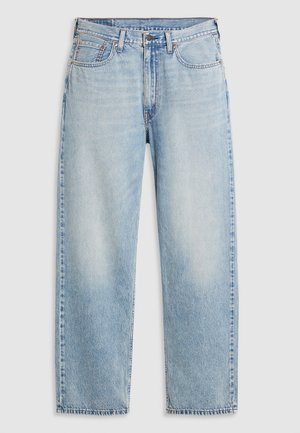 Ljusblå raka jeans med fem fickor, metallknappstängning och blekna detaljer på låren och knäna, liggande platt på vit bakgrund.