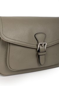 Borsa in pelle di un verde oliva tenue, caratterizzata da una forma rettangolare strutturata, chiusura con fibbia regolabile e dettagli di cucitura sottili.
