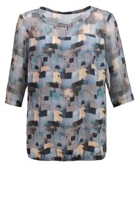 Blusa trasparente a maniche corte di colore blu con motivi geometrici astratti in crema e nero. Presenta un Collo rotondo e un orlo elastico.