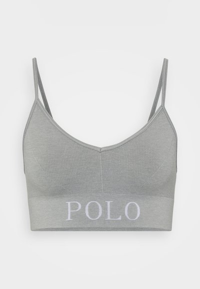 Pelēkā ribota bralette ar plānām regulējamām siksniņām un biezu joslu apakšā, uz kuras baltā krāsā ir uzraksts "POLO". Gluda tekstūra.