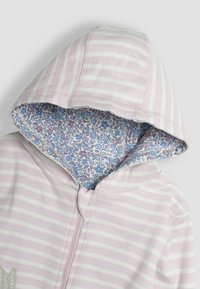 Sudadera con capucha a rayas en color rosa, con un forro de estampado floral. Cuenta con un cierre de cremallera y está hecha de material de algodón suave.