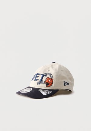 Beige og marineblå Detroit Tigers baseballcaps med brodert lagnavn og tigerlogo, buet brem og merkeetiketter på visiret.