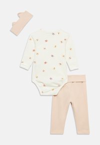 Σετ βρεφικών ρούχων από βαμβάκι που περιλαμβάνει ένα κρεμ κορμάκι με σχέδιο πεταλούδας και φιόγκου, ροζ κολάν και ταιριαστή κορδέλα για το κεφάλι.