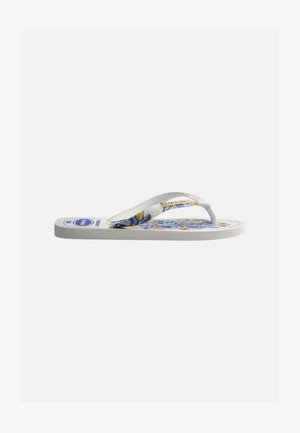 Λευκή παντόφλα τύπου σαγιονάρα με μπλε φλοράλ σχέδιο στη σόλα και λευκές υφασμένες λουρίδες, εμφανιζόμενη από το πλευρό σε απλό φόντο.