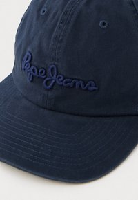 Tumši zila beisbola cepure ar izliekto malu un izšūtu tumši zilo "Pepe Jeans" logo uz priekšējā paneļa.