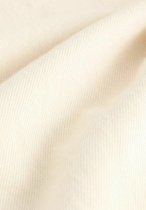 Cremefarbener, gerippter Stoff zeigt eine sanfte Textur mit subtiler Ausstrahlung und unterschiedlichen Tiefen in Wellen, die seine leichte und atmungsaktive Qualität hervorheben.