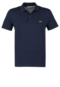 Paita polo biru navy yang terbuat dari katun lembut, dilengkapi dengan kerah dua kancing dan logo buaya hijau kecil di dada kiri. Lengan pendek.