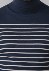 Maglione a collo alto blu navy con strisce bianche orizzontali. Tessuto morbido, design aderente e dettagli a coste nel colletto e nell'orlo.