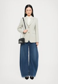 Light gray blazer, wide-leg blue denim jeans, white striped blouse, and a small black crossbody bag. Gold button accents on the blazer.