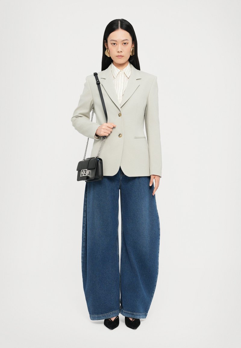 Light gray blazer, wide-leg blue denim jeans, white striped blouse, and a small black crossbody bag. Gold button accents on the blazer.