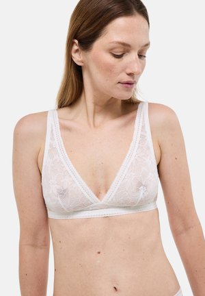 Bralette en dentelle blanche avec un décolleté en V profond et des bretelles larges. Motif floral et bords festonnés sont des éléments de design marquants.