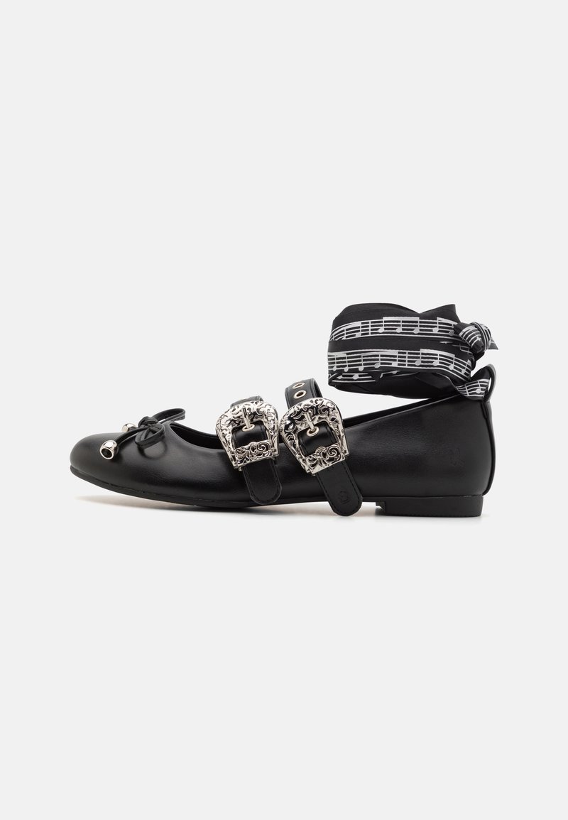 Black ballet flats with dual silver buckles, bow detail, and a musical note ribbon. Smooth texture and rounded toe design.
