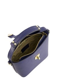 Purple textured leather handbag with a zip closure, gold hardware accents, and a spacious interior featuring a fabric lining and pockets.