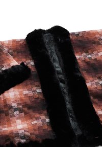 Faux fur-kappa med en svart pälskrage och kanter, med ett rutmönster i bruna, rostiga och beige nyanser. Mjukt material.