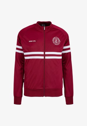 Chaqueta roja con cremallera hecha de una tela suave, que presenta rayas verticales blancas y un logo en el lado izquierdo del pecho. Puños y dobladillo acanalados.