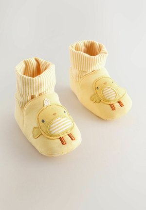 Žlté detské botičky so pruhovaným manžetovým lemom, na prednej strane s vyšitým dizajnom kuriatka a mäkkou tkaninou pre pohodlie.