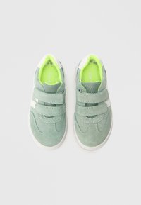 Rohelised seemisnahast tossud võrgust detailidega, valgete aktsentide ja kahe takjakinnitusega. Neoonrohelised sisetallad ja polsterdatud ääred mugavuse tagamiseks.