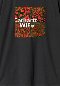 Czarna koszulka z kwadratową grafiką z kolorowymi czerwonymi kwiatami oraz białym napisem "Carhartt WIP®". Materiał bawełniany o gładkiej fakturze.