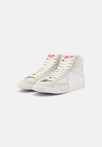 Höga sneakers med en färgsättning i kräm och grått, med en kombination av läder och mocka, krämfärgade snören och en strukturerad gummisula.