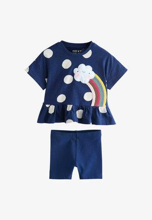 Marineblaues Kleinkind-Outfit mit weißem gepunktetem Rüschentop, das eine lächelnde Wolke und einen gestickten Regenbogen zeigt, kombiniert mit schlichten Shorts.