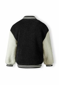 Mustvalge faux-fur jakk tekstuurse kehaga, kontrastsete varrukatega ning triibuliste kudumite aktsentidega krael ja mansettidel.